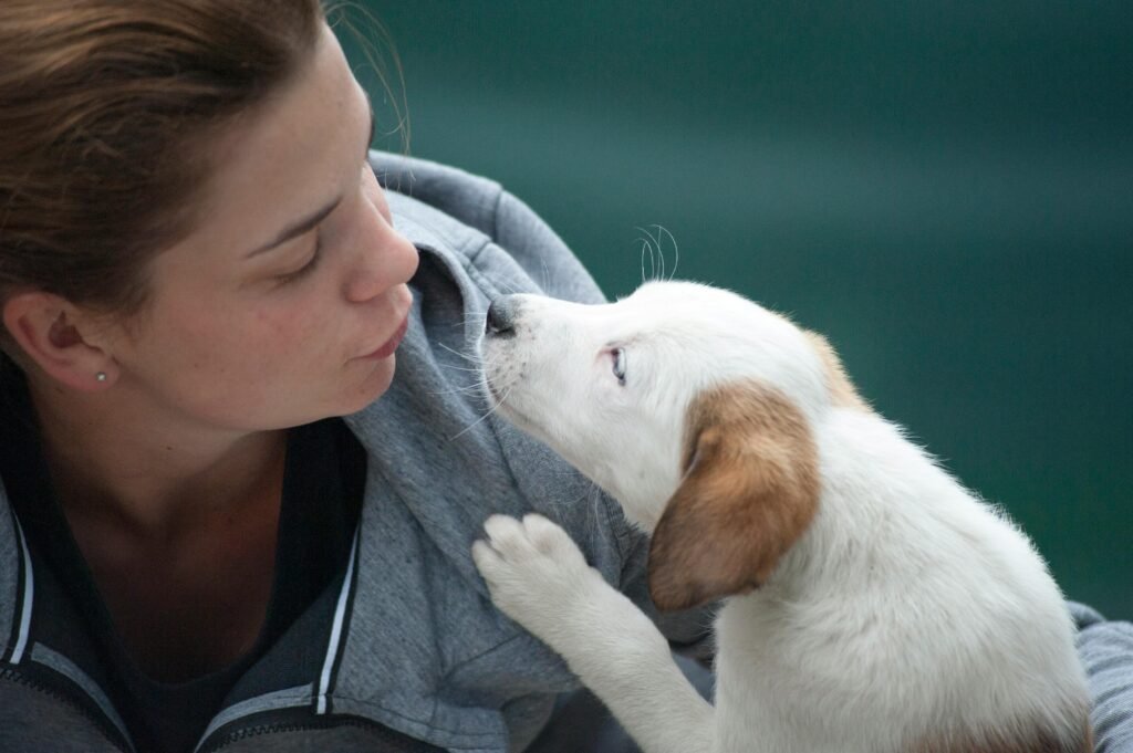 🐶 10 Mistakes First-Time Dog Owners Make A candid shot of a woman and puppy sharing a tender moment outdoors.